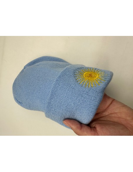 GORRO TEJIDO CELESTE CON BORDADO SOL DE MAYO